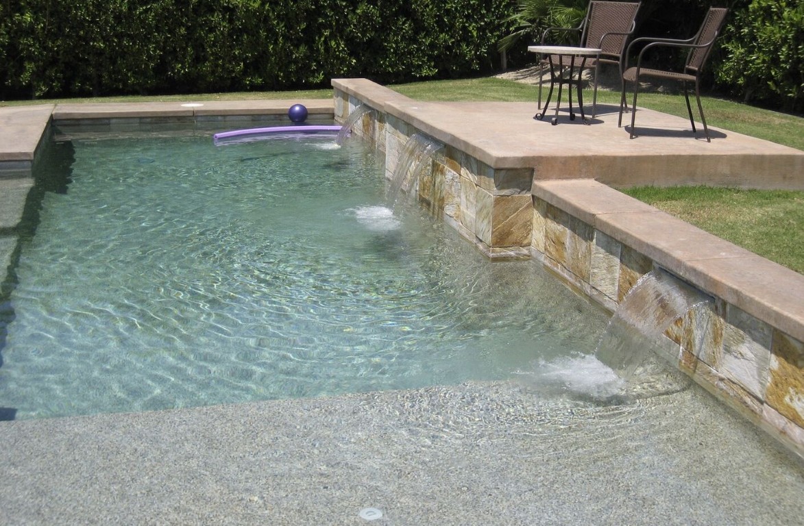 Natural stone pool with water features maintained by BlueAxis in Seguin, TX